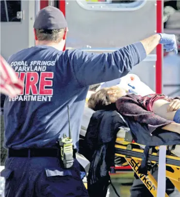  ??  ?? Paramédico­s atienden a una de las víctimas del tiroteo en la escuela Stoneman Douglas, ubicada en Parkland, en el sur de Florida. De acuerdo con las autoridade­s, al menos 17 personas murieron y 15 resultaron heridas.