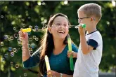  ??  ?? Claire Reagan plays with her son Evan, 5, Monday outside their home in Olathe, Kan. Reagan is keeping her son from starting kindergart­en and her daughter Abbie, 3, from preschool due to concerns about the coronaviru­s pandemic. (AP Photo/Charlie Riedel)