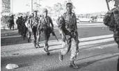  ?? AMANUEL SILESHI AFP VIA GETTY IMAGES ?? Soldiers from the Ethiopian National Defense Force walk in the streets of Kombolcha, Ethiopia.