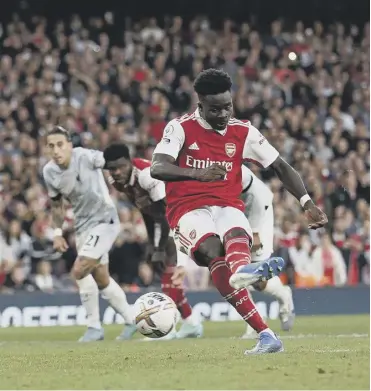  ?? ?? ↑ Bukayo Saka scores Arsenal’s third goal from the penalty spot to secure victory over Liverpool