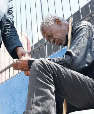  ?? NORMAN GRINDLEY/CHIEF PHOTO EDITOR ?? Percival McIntosh, who is blind, and who has fallen on hard times, sitting on the sidewalk in Half-Way Tree, St Andrew, begging for a living.