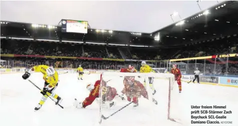  ?? KEYSTONE ?? Unter freiem Himmel prüft SCB-Stürmer Zach Boychuck SCL-Goalie Damiano Ciaccio.