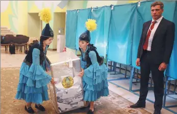  ?? PAVEL MIKHEYEV / REUTERS ?? Members of a local election committee carry a ballot box before counting votes during the presidenti­al election in Almaty, Kazakhstan, on Sunday.