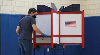  ?? NAnCy lAnE / hErAld stAff filE ?? KEEP IT CLEAN: Newton polling inspector Bruce Warren cleans voting booths in the Sept. 1 primary. The ‘ranked choice’ voting initiative appears as Question 2 on the November ballot.