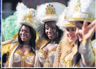  ??  ?? HAT THE READY Performers prepare for the parade