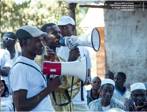  ??  ?? African NGO activists delivering a public lesson to village elders in rural Guinea-Bissau