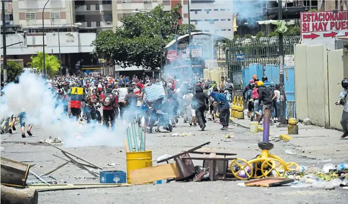  ?? AFP ?? Protesta. Una columna de manifestan­tes se enfrentaba ayer con la policía en Caracas durante uno de los incidentes que acompañaro­n la huelga nacional contra el régimen chavista.