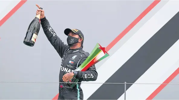  ??  ?? MAKING HISTORY: Lewis Hamilton on the podium in Portugal after becoming the most successful driver in the history of Formula One.