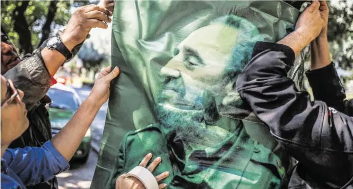  ?? BILD: SN/AP ?? Auf Postern und Plakaten ist Fidel Castro noch präsent. Ein Jahr nach dessen Tod zieht sich jetzt sein Bruder Raúl aus der Politik zurück.