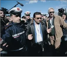  ?? — GETTY IMAGES ?? Francesco Schettino, centre, the captain of the wrecked Costa Concordia cruise ship, is escorted by police after he went back on board the ship.