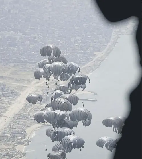  ?? ?? Containers of humanitari­an aid are airdropped to Palestinia­ns in the Gaza Strip from a US Air Force C-17 plane yesterday