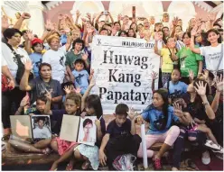  ??  ?? NEVER FORGET THEM – Portraits of the victims of extra-judicial killings are displayed by their relatives after a mass for the victims at the Our Lady of Victory Chapel in Malabon City Thursday. (Federico Cruz)