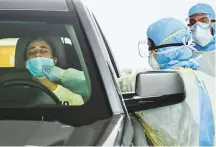  ?? Gulf News archives ?? Paramedics collecting swab samples at a coronaviru­s drive-through screening station by DHA in Dubai.