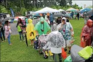  ?? LAUREN HALLIGAN - MEDIANEWS GROUP FILE ?? Event-goers use ponchos and umbrellas while waiting in