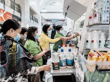  ?? LAM YIK FEI/THE NEW YORK TIMES ?? Evidence that deep cleaning lessens the threat of the virus indoors is scarce. Above, people buy cleaner in Hong Kong.