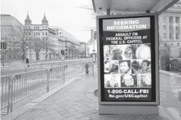  ?? SUSAN WALSH/AP ?? A bus stop along Pennsylvan­ia Avenue displays a poster from the FBI seeking informatio­n on the Capitol rioters last month in Washington, D.C.