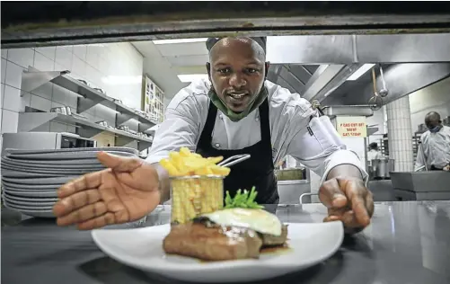  ?? Pictures: Sebabatso Mosamo ?? BON APPETIT Chef Simphiwe Mzindle plates a classic at the Fairway Hotel in Randburg — steak and chips.