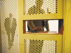  ?? Jim Wilson / New York Times ?? A guard stands outside a cell at Pelican Bay State Prison in Crescent City. Inmates in a riot there can be charged with assault, a court ruled.