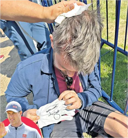  ?? ?? Consolatio­n: Christophe­r Ineson is treated as he holds a signed glove from Adam Scott (inset)