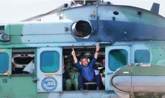  ?? EFE ?? El presidente de Brasil, Jair Bolsonaro, saludó a sus seguidores mientras sobrevuela el acto a bordo de un helicópter­o, ayer