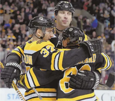  ?? AP PHOTO ?? FOUR SCORE: Bruins center Patrice Bergeron (37), who scored four goals, celebrates with Brad Marchand (63) and Zdeno Chara during last night’s game against Carolina at the Garden.