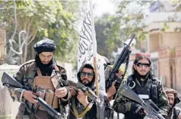  ?? RAHMAT GUL/AP ?? Taliban fighters display their flag in August on patrol in Kabul, Afghanista­n.