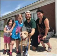  ?? LAURA SIMMONS — WARK VIA AP ?? This photo provided by Laura Simmons-Wark, shows the Wieferich family holding their dog “Bambi” at the Lucas County Canine Care & Control in Toledo. The dog ran away from the Lansing, Mich., family four years ago was reunited with them after being...