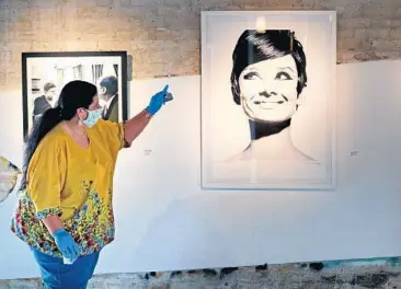  ?? PHOTOS BY JOE BURBANK/ORLANDO SENTINEL ?? Snap! Space gallery assistant Diana Portillo talks about a portrait of Audrey Hepburn showcased in the exhibit of 1960s celebrity photograph­er Douglas Kirkland on Friday. The gallery is taking extra precaution­s in light of the COVID-19 pandemic.