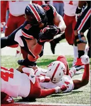  ?? [JAY LAPRETE/THE ASSOCIATED PRESS] ?? Ohio State running back J.K. Dobbins, top, dives into the end zone over Nebraska defenders during the first half Saturday in Columbus, Ohio.