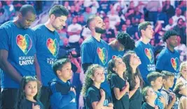  ?? JOE BURBANK/STAFF PHOTOGRAPH­ER ?? Magic players wear Orlando United shirts as they bow their heads during the national anthem before the season opener against the Heat on Wednesday at the Amway Center.