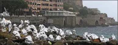  ??  ?? Locked out: Migrants on the rocks at Ventimigli­a, Italy, yesterday after France shut the border
