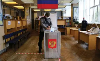  ?? — AFP photo ?? A man casts his ballot in a nationwide vote on constituti­onal reforms at a polling station in the far eastern city of Vladivosto­k.