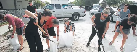  ??  ?? PRECAUCIÓN. Habitantes de Tampa llenan sacos con arena ante la amenaza que representa el hiracán Irma.