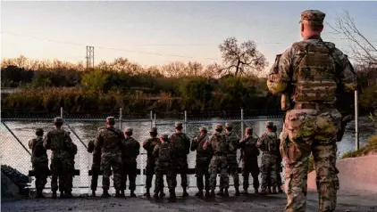  ?? Brandon Bell/getty Images ?? National Guard soldiers stand guard on the banks of the Rio Grande river at Shelby Park in Eagle Pass, Texas. The Texas National Guard continues its blockade and surveillan­ce of Shelby Park in an effort to deter illegal immigratio­n. The Department of Justice has accused the Texas National Guard of blocking Border Patrol agents from carrying out their duties along the river.