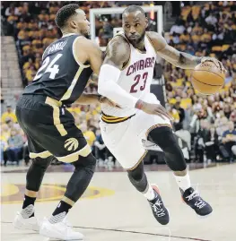  ??  ?? Cavaliers forward LeBron James drives past Raptors forward Norman Powell during the first half of Game 2 in Cleveland.