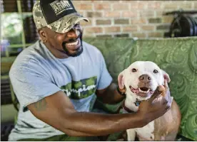  ?? BY ANDREW RUSH / PITTSBURGH POST-GAZETTE
PHOTOS ?? Omar Brooks pets Maisie Mae, a foster dog at Bridge To Home Animal Rescue in Eighty Four, Pa. Brooks and his family have been fostering dogs for the past two years.