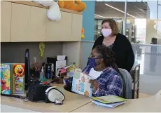  ?? (Special to The Commercial/Deborah Horn) ?? Employee Michelle Washington (seated) talks with Pine Bluff/Jefferson County Library System’s Director Barbara “Bobbie” Morgan.