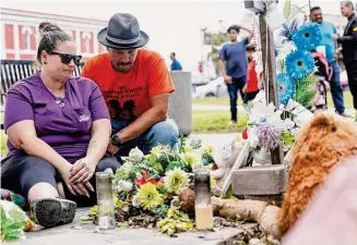 ?? Photos by Sam Owens/Staff photograph­er ?? Nikki and Brett Cross take a quiet moment to themselves to visit the memorial for their nephew, Uziyah Garcia, at the Town Square while attending a Get Out the Vote rally on Oct. 8 in Uvalde.