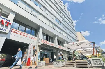  ??  ?? People walk past a building where the Kiev office of Russia’s state-run RIA Novosti news agency are housed. — AFP photo