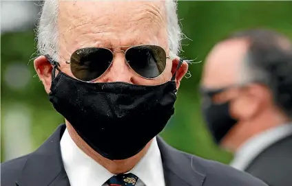  ?? AP ?? Joe Biden’s mask at a Memorial Day ceremony in Delaware was in stark contrast to Donald Trump’s bare face the same day.