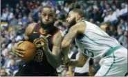  ?? MICHAEL DWYER — THE ASSOCIATED PRESS FILE ?? Cleveland Cavaliers’ LeBron James (23) drives against Boston Celtics’ Marcus Morris (13) during the third quarter of an NBA basketball game in Boston. They both took winding paths to get here, but the Cleveland Cavaliers and Boston Celtics are back in...