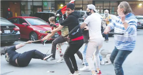  ?? THE CANADIAN PRESS/CHRIS YOUNG ?? Pro-Isreal and pro-Palestine supporters brawl at a demonstrat­ion in Toronto Saturday.