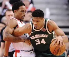  ?? FRANK GUNN, THE CANADIAN PRESS ?? Milwaukee Bucks forward Giannis Antetokoun­mpo drives as Toronto Raptors guard DeMar DeRozan defends during first-half action in Toronto on Monday.