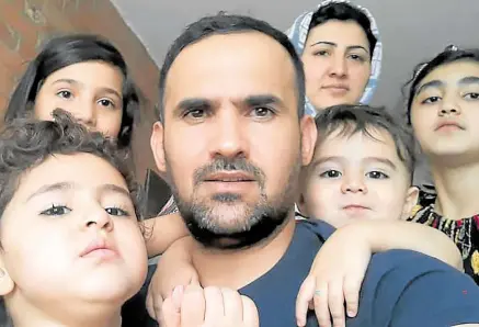  ?? —PHOTOS BY AFP ?? BLESSED Ehsan Saadat (center), a 33-year-old Afghan researcher on corruption and human rights, recently arrived in Toronto, Canada, with his wife and children. The family, shown here on Aug. 17, fled Afghanista­n just before the fall of Kabul.