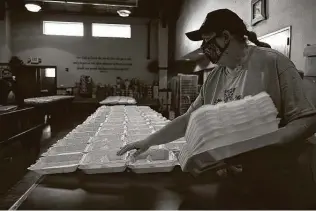  ?? Lisa Krantz / Staff photograph­er ?? Dianne Talbert, executive director of Communitie­s Under the Bridge, sets out meal containers for Christmas dinner. As a teen, Talbert experience­d homelessne­ss herself before joining the Air Force.