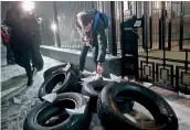  ?? –AFP ?? A man places a paper boat in front of the Russian Embassy in Kiev late on Sunday during a protest following the seizure of Ukrainian naval ships.