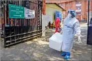  ??  ?? A health staff worker wearing protective gears carries samples box for the testing of Covid-19 disease at LNJP hospital in New Delhi on Saturday. ANI Photo