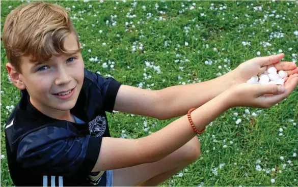  ??  ?? HAIL STORM: Quinn Farmer collects hail after it fell in Rangeville on October 26. PHOTO: KEVIN FARMER