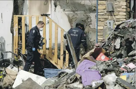  ?? LARRY WONG ?? Police and fire investigat­ors sift through the remains of a home located at 1040 Armitage Crescent on Thursday. A fire destroyed the home, killing a five-month-old boy. The mother, Angie Tang, remains in hospital in critical condition. The fire is...