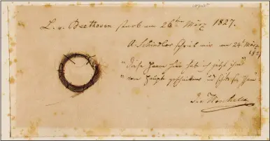  ?? (AP/Ira F. Brilliant Center for Beethoven Studies/San Jose State University) ?? The Moscheles Lock from Beethoven is seen with an inscriptio­n by former owner Ignaz Moscheles.